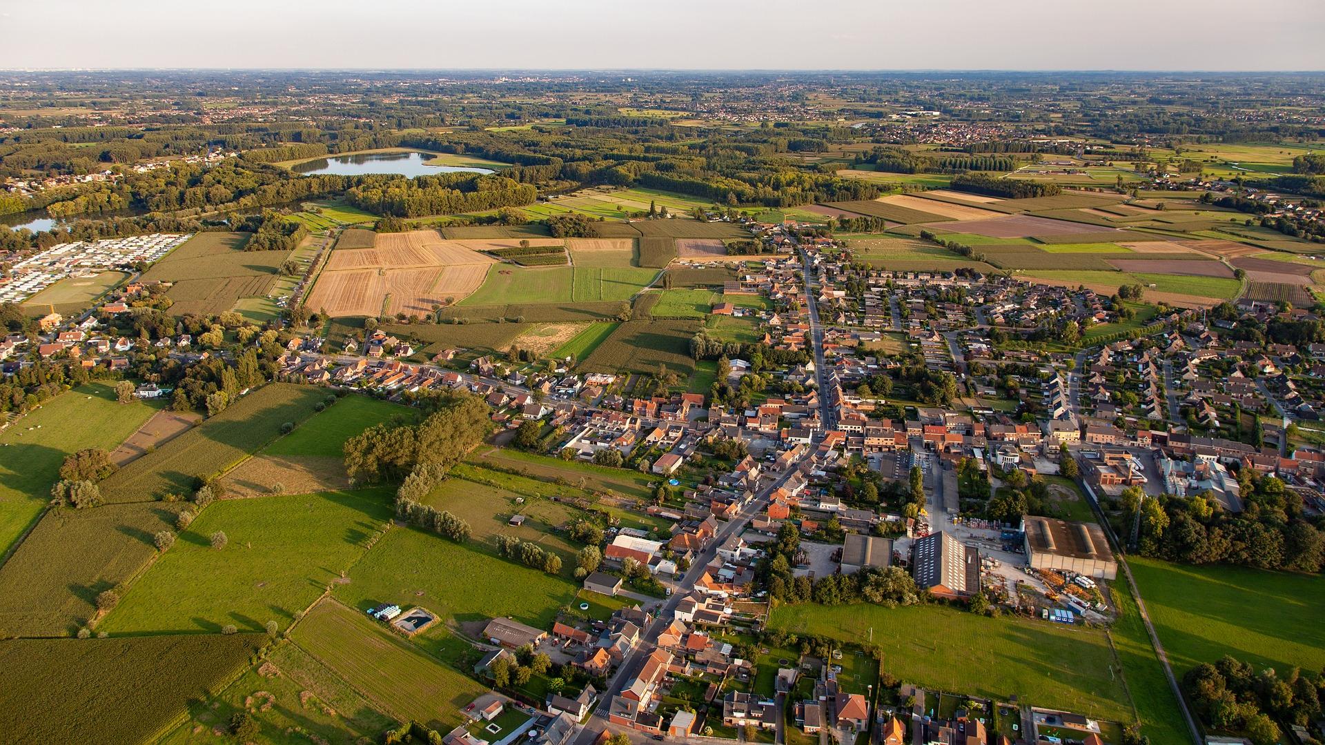 Luchtfoto van een Nederlands dorp met akkers er omheen